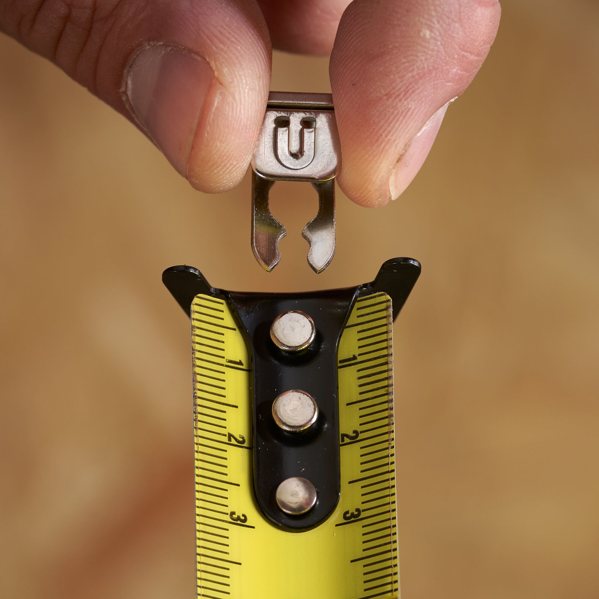STANLEY STHT37232 tape measure close-up with yellow blade and accessory held by hand.